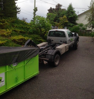 Roll Off Dumpster Getting Lifted Onto Truck